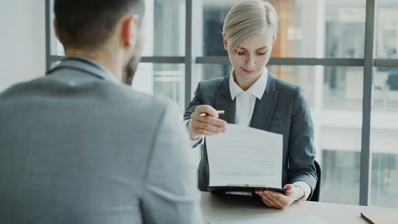 Advogada apresentando um documento a um cliente em reunião